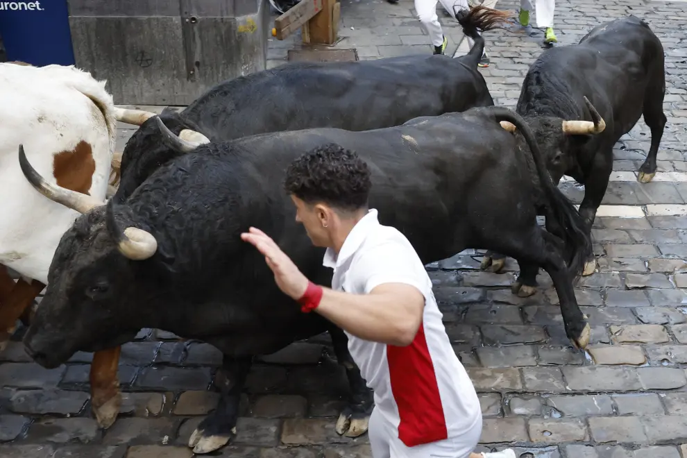 PAMPLONA, 12/07/2024.- Los mozos son perseguidos por toros de la ganadería de Jandilla, de Mérida (Badajoz), durante el sexto encierro de los Sanfermines 2024, este viernes en Pamplona. EFE/Villar López
