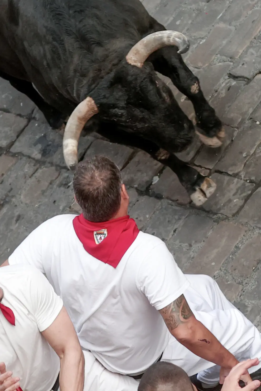 PAMPLONA, 12/07/2024.- Un mozo ante un toro de la ganadería Jandilla durante el sexto encierro de los Sanfermines 2024 celebrado este viernes en Pamplona. EFE/Jesús Diges
