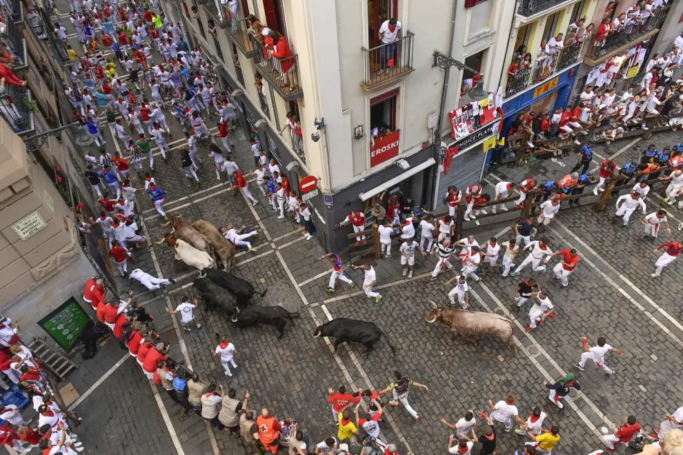 Revelers run with bulls from the Jandilla ranch during the sixth day of the running of the bulls at the San Fermín fiestas in Pamplona, Spain, Friday, July12, 2024. People test their speed and bravery by dashing with six fighting bulls through the streets of the northern Spanish city of Pamplona. (AP Photo/Alvaro Barrientos)