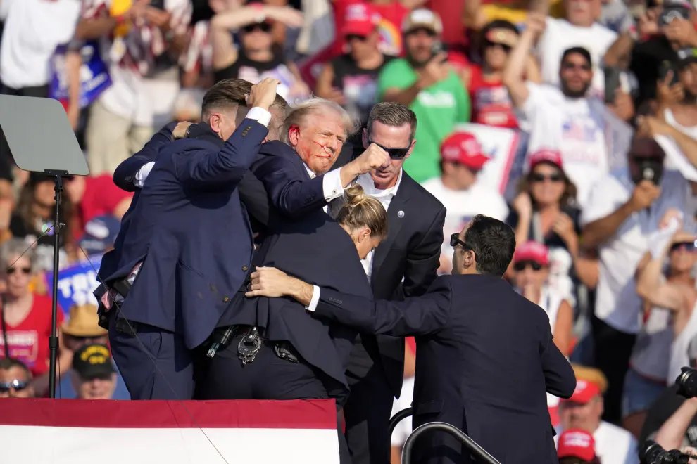 Republican presidential candidate former President Donald Trump is helped off the stage at a campaign event in Butler, Pa., Saturday, July 13, 2024. (AP Photo/Gene J. Puskar)