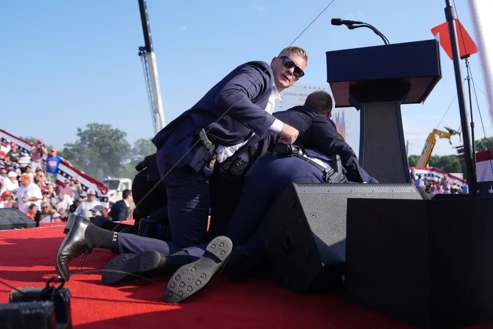 Republican presidential candidate former President Donald Trump is covered by U.S. Secret Service agents at a campaign rally, Saturday, July 13, 2024, in Butler, Pa. (AP Photo/Evan Vucci)