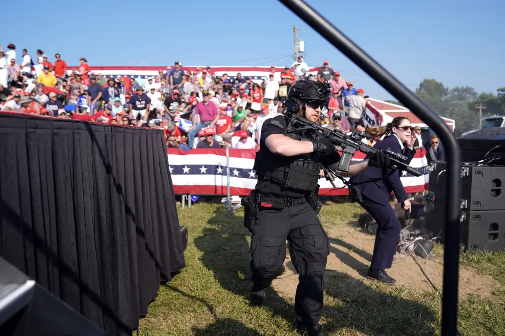 Republican presidential candidate former U.S. Secret Service agents rush the stage during. Campaign rally with Republican presidential candidate former President Donald Trump Saturday, July 13, 2024, in Butler, Pa. (AP Photo/Evan Vucci)
