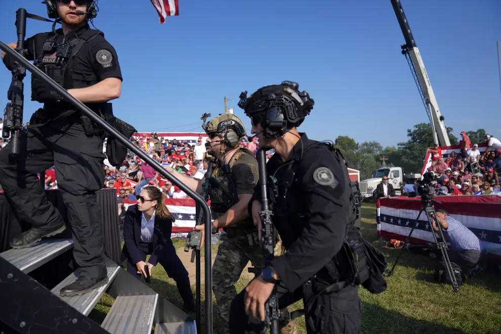 Republican presidential candidate former U.S. Secret Service agents rush the stage during. Campaign rally with Republican presidential candidate former President Donald Trump Saturday, July 13, 2024, in Butler, Pa. (AP Photo/Evan Vucci)