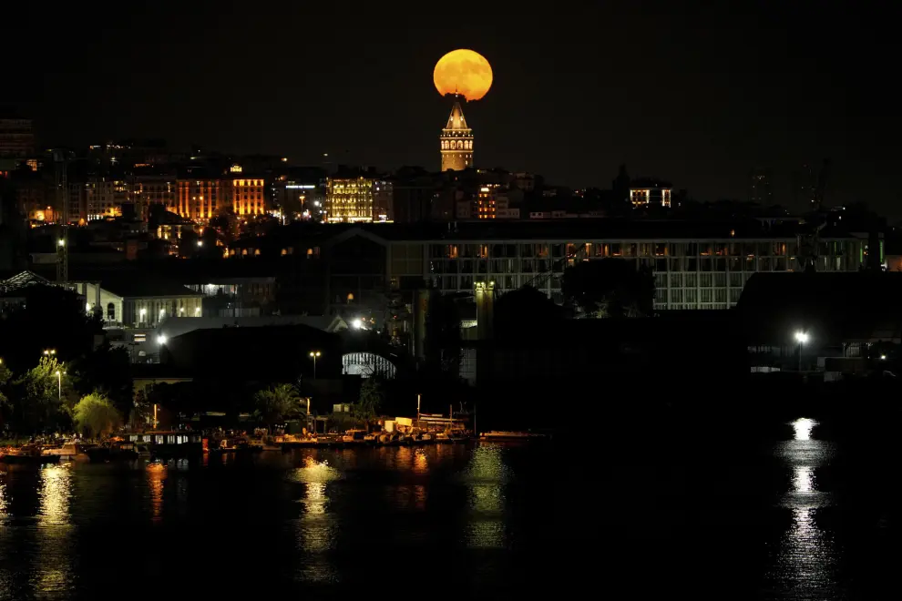 A full moon rises behind Galata Tower landmark in Istanbul, Turkey, Sunday, July 21, 2024. (AP Photo/Emrah Gurel)