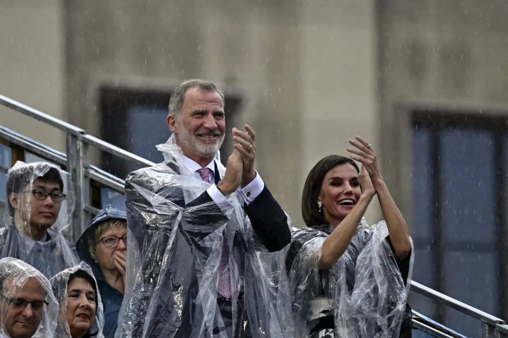 Spain's King Felipe VI, left, and his wife Queen Letizia applaud as rain falls during the opening ceremony for the 2024 Summer Olympics in Paris, France, Friday, July 26, 2024. (Loic Venance/Pool Photo via AP)