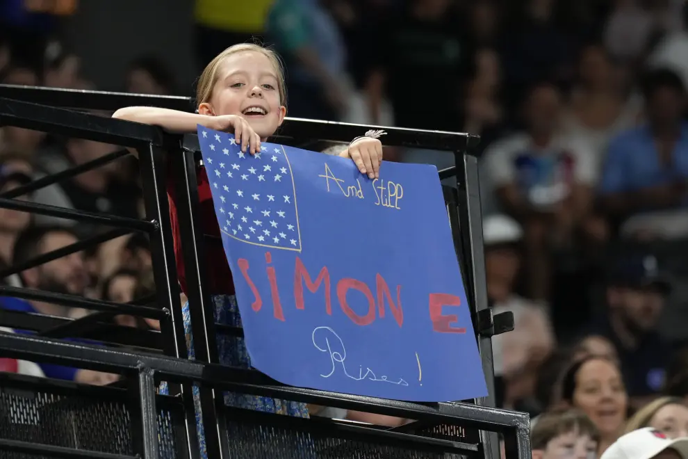 A young fan supports Simone Biles and Team USA during a women's artistic gymnastics qualification round at the 2024 Summer Olympics, Sunday, July 28, 2024, in Paris, France. (AP Photo/Abbie Parr)