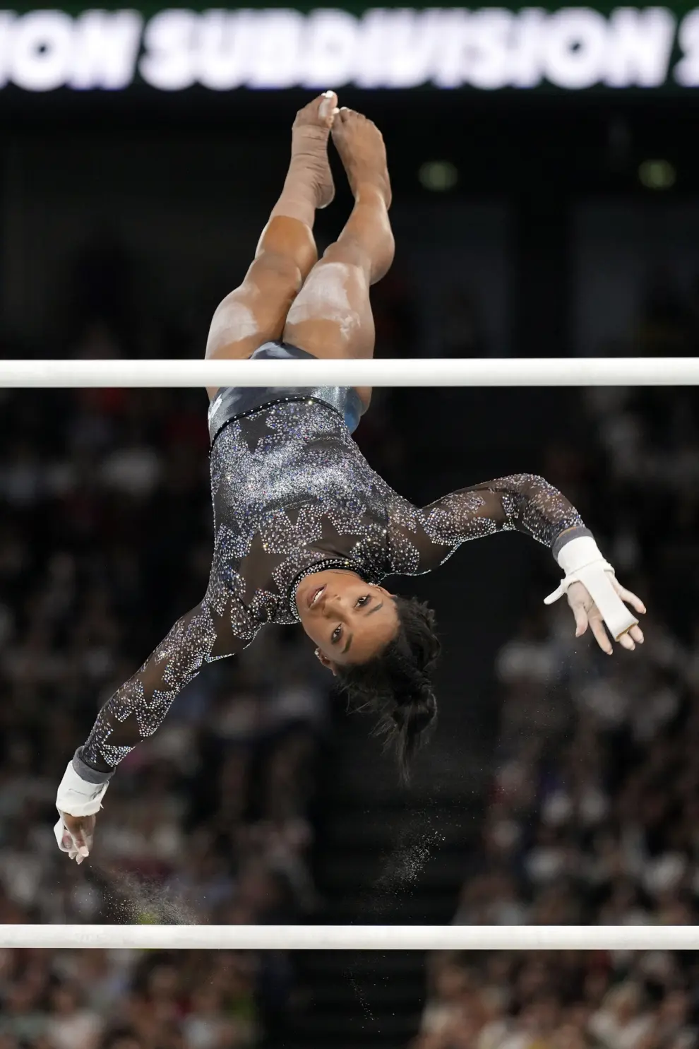 Simone Biles, of United States, competes on the uneven bars during a women's artistic gymnastics qualification round at Bercy Arena at the 2024 Summer Olympics, Sunday, July 28, 2024, in Paris, France. (AP Photo/Abbie Parr)