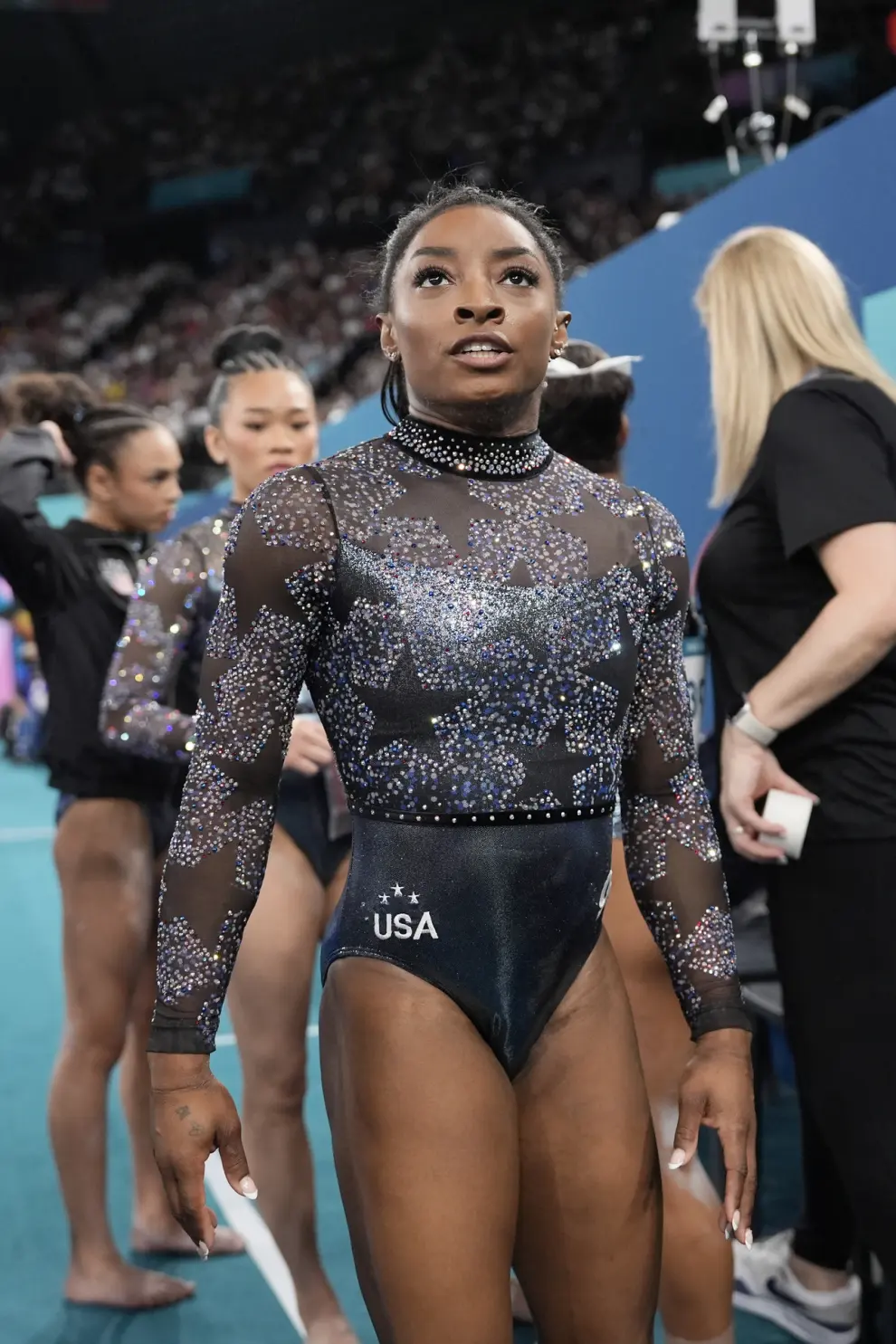 Simone Biles, of United States, walks on the competition floor after competing on the floor exercise during a women's artistic gymnastics qualification round at Bercy Arena at the 2024 Summer Olympics, Sunday, July 28, 2024, in Paris, France. (AP Photo/Charlie Riedel)