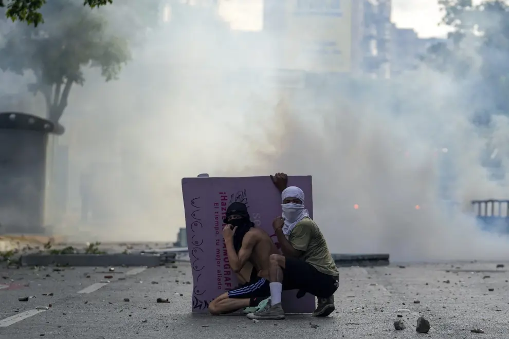 A protestor raises his arms in front of tires on fire in Caracas, Venezuela, Monday, July 29, 2024, the day after the presidential election. (AP Photo/Matias Delacroix)..Associated Press/LaPresse [[[AP/LAPRESSE]]]