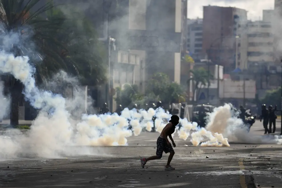 Protesters take cover during clashes with police in demonstrations against the official election results declaring President Nicolas Maduros reelection, the day after the vote in Caracas, Venezuela, Monday, July 29, 2024. (AP Photo/Matias Delacroix)..Associated Press/LaPresse [[[AP/LAPRESSE]]]