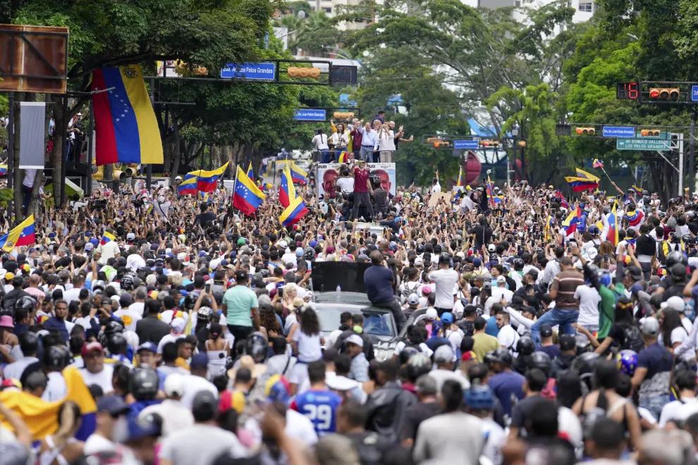 National Guards on motorcycles, behind, chase people on motorcycles demonstrating against the official election results declaring President Nicolas Maduro won reelection in Caracas, Venezuela, Tuesday, July 30, 2024, two days after the vote. (AP Photo/Matias Delacroix) [[[AP/LAPRESSE]]]