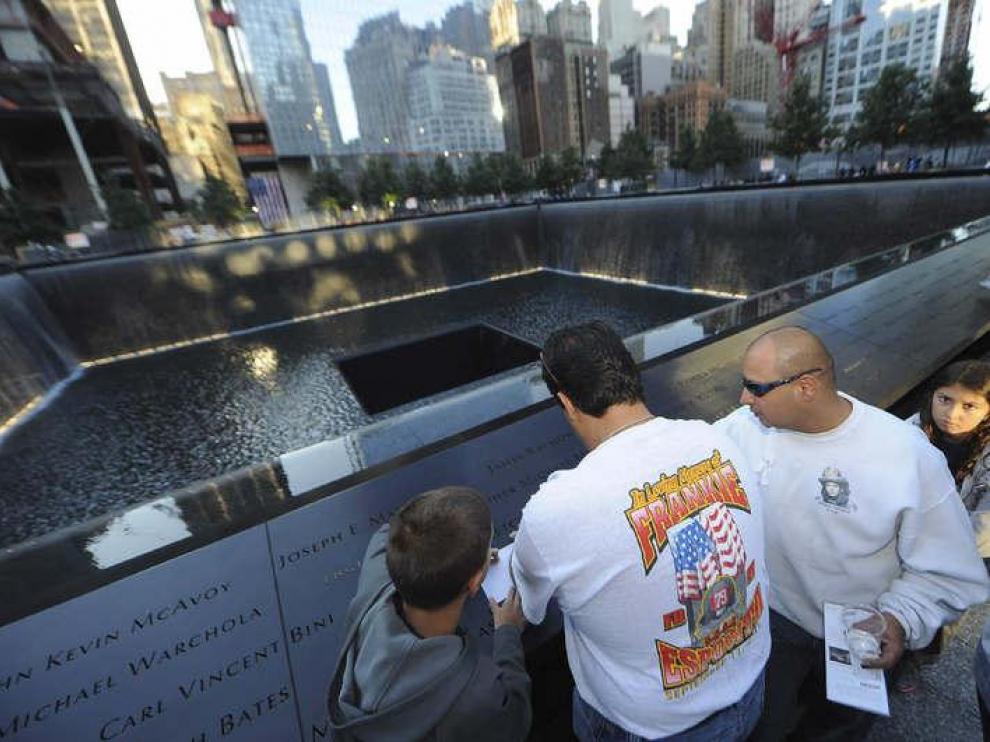 Varias personas participan en una ceremonia para conmemorar a las víctimas de los atentados terroristas de 2001 en el lugar donde se encontraba el World Trade Center