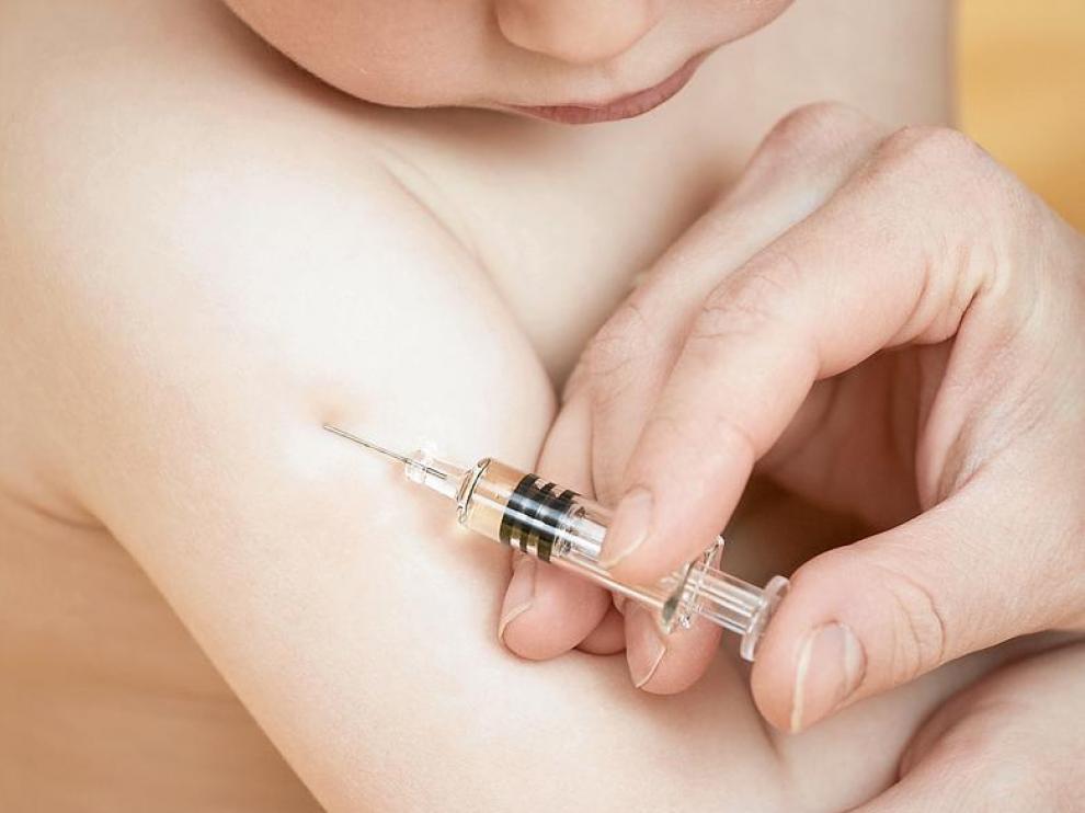 Un pediatra vacuna a un niño.