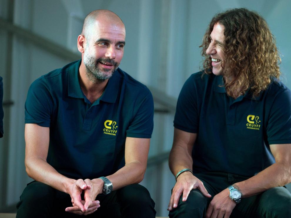 Pep Guardiola junto a Carles Puyol en el acto de la Fundación Cruyff