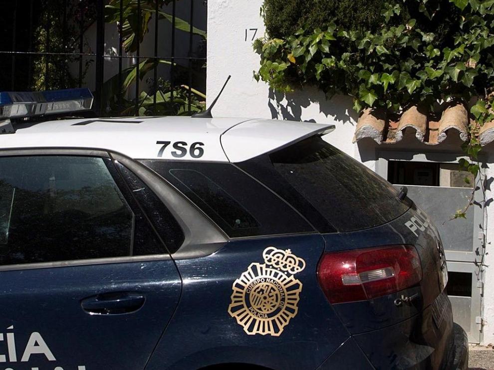 Dos miembros de la Policía Nacional custodian la vivienda donde anoche una mujer de 58 años y de nacionalidad española fue asesinada a puñaladas por su pareja en Estepona (Málaga).