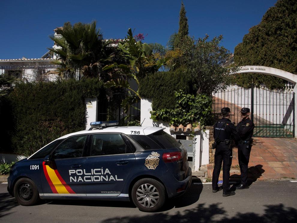 Dos miembros de la Policía Nacional custodian la vivienda donde anoche una mujer de 58 años y de nacionalidad española fue asesinada a puñaladas por su pareja en Estepona (Málaga).
