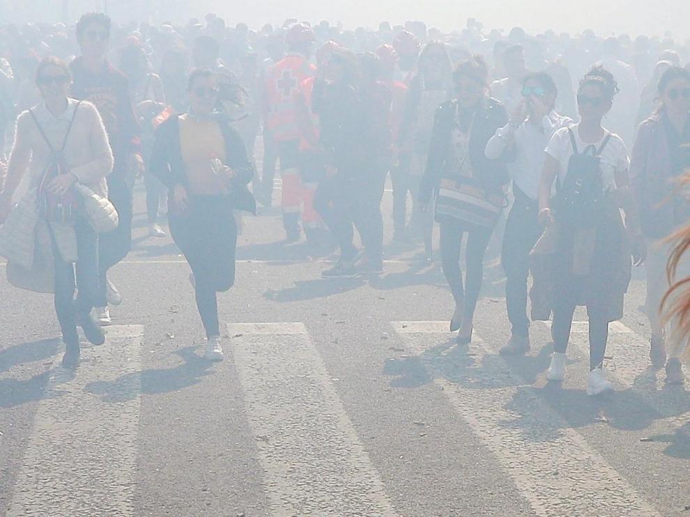 Una aglomeración humana atraviesa la humareda tras el disparo de la última Mascletá oficial de las Fallas en Valencia.