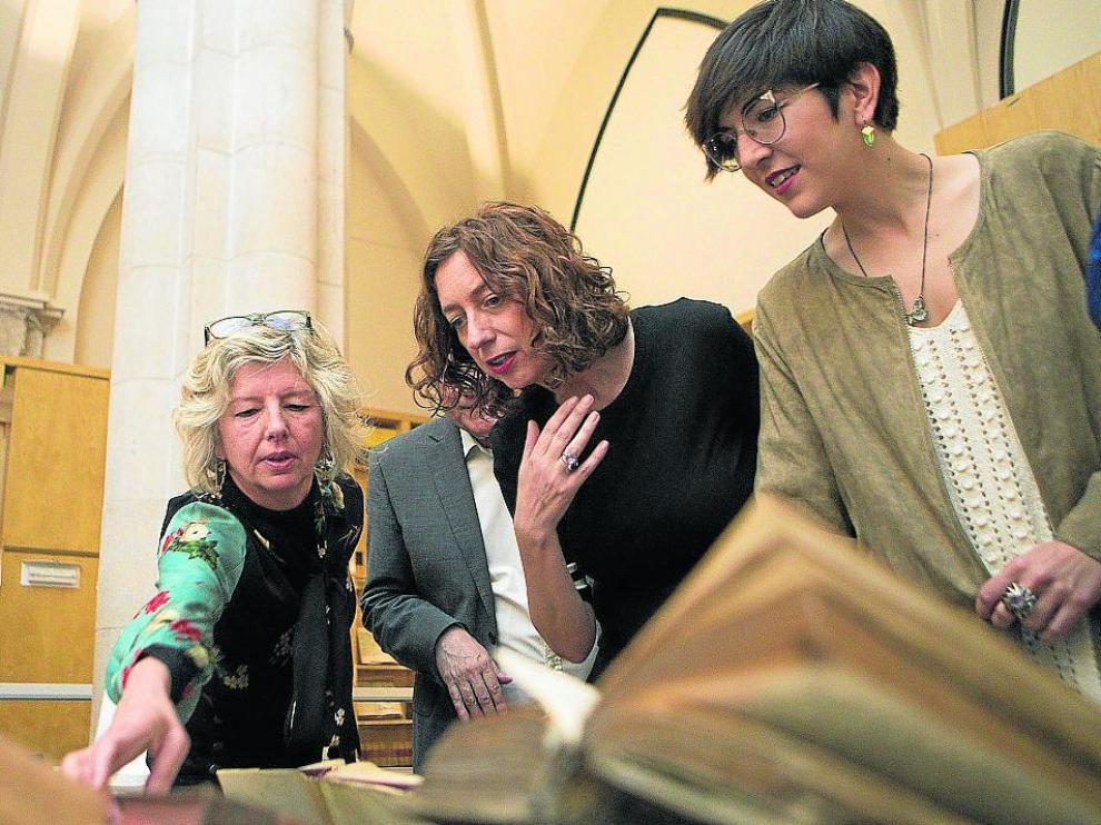 Gascón, con Patricia Luquin y Violeta Barba, ayer, contemplan ejemplares cedidos a las Cortes.