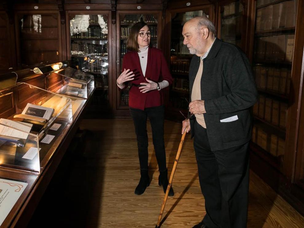 Paz Miranda, organizadora de la muestra, y Eloy Fernández Clemente, supervisor de la misma, en la Biblioteca de la Universidad de Zaragoza.