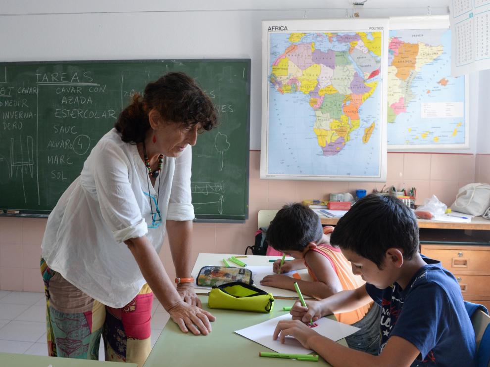 Delfi Ruiz Fernández, maestra de la escuela de Olba, del CRA Javalambre (Teruel), observa el trabajo de dos de sus alumnos