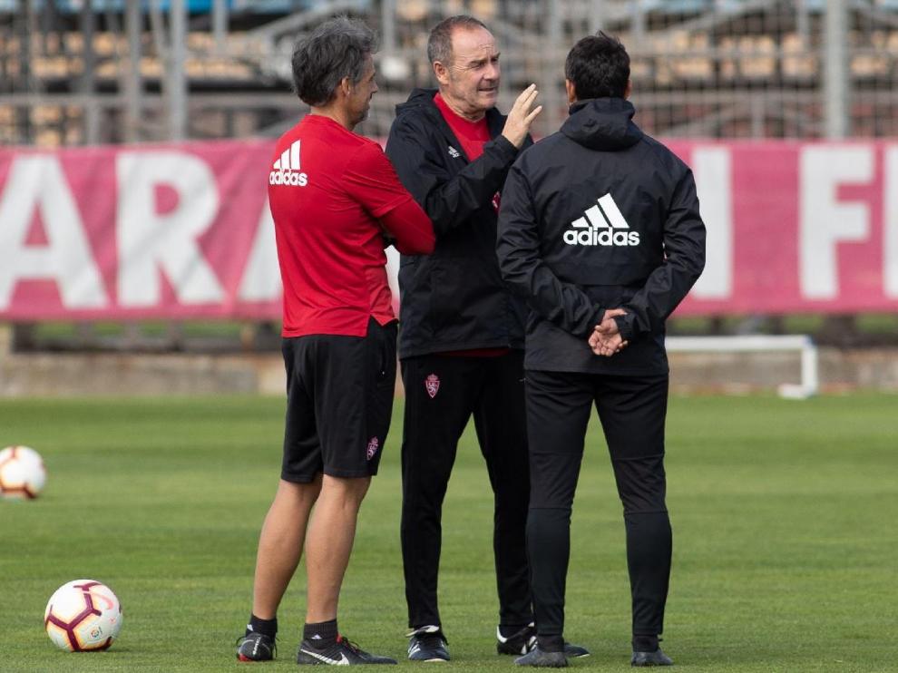 Víctor Fernández, Roberto Cabellud (izda.) y José Luis R. Loreto (dcha, de espaldas), el cuerpo técnico del Real Zaragoza charla durante el entrenamiento del miércoles.