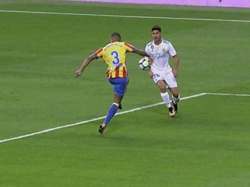 Mano involuntaria de Vezo, defensor del Valencia, en el Bernabéu. Este año no fue considerada penalti. A partir del 1 de julio, lo será.