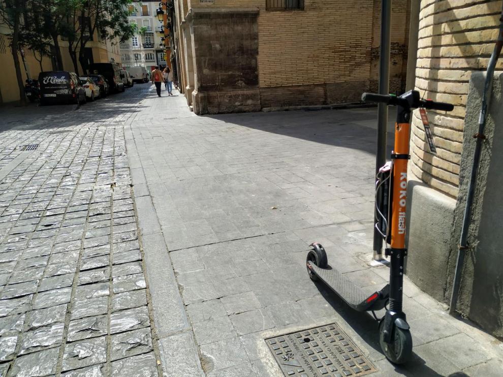 El patín, con el boletín de denuncia, en la acera de la calle de Agustines, junto a la Audiencia de Zaragoza.