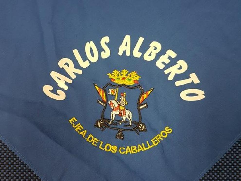 El pañuelo es azul y lleva bordado el escudo y el nombre del niño o niña.