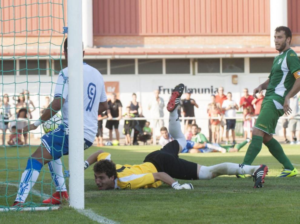 Ángel, delantero centro del Real Zaragoza, marca el 1-1 ante la mirada del capitán del Ebro, José Carlos Gil, y del portero Loscos en el partido jugado en La Almunia de Doña Godina en julio de 2015.