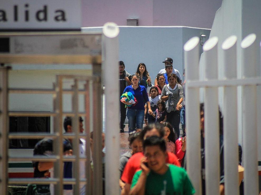 Decenas de inmigrantes retornan este martes a México por la garita del chaparral, en la ciudad de Tijuana.