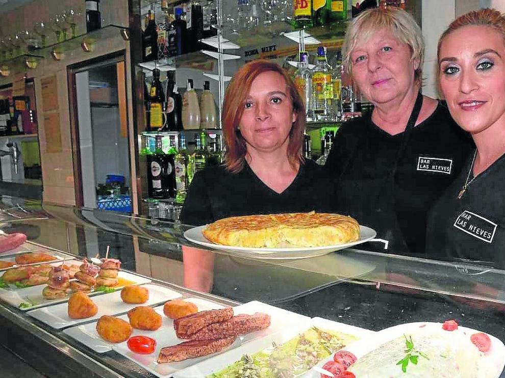 Elena Calavia, Pilar Ladrero y Esther Hidalgo, del bar Las Nieves, con su tortilla y la variada barra.