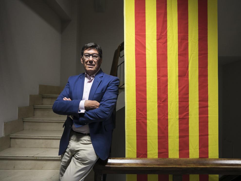El presidente del PAR, Arturo Aliaga, junto a la bandera que preside la sede de su partido, en el Coso de Zaragoza.