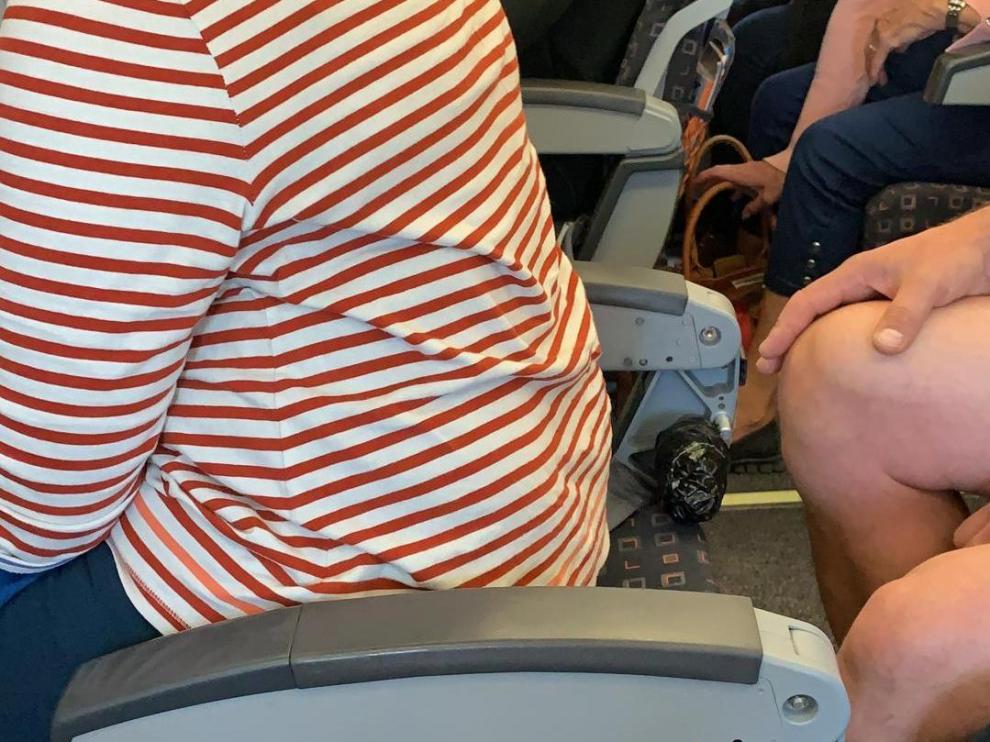 La imagen muestra a una mujer en un asiento sin respaldo en un vuelo de EasyJet.