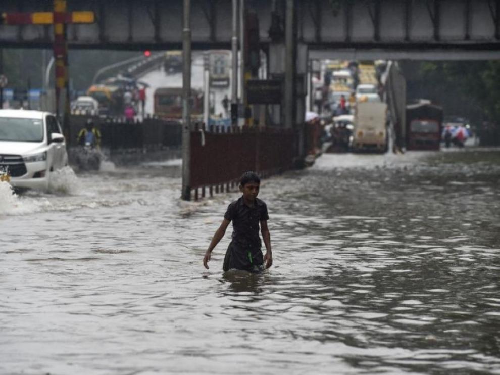 Un joven huye de la corriente de agua provocada por las lluvias.