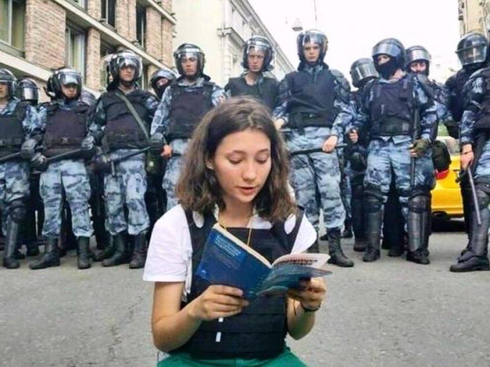 La joven Olga Misik leyendo la constitución frente a la policía.