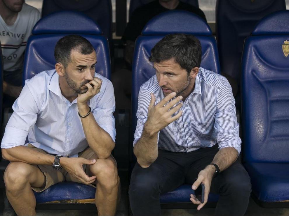 Miguel Linares y Lalo Arantegui, el sábado una hora antes del Real Zaragoza-Tenerife del debut liguero, charlan en el banquillo de La Romareda. El delantero aragonés no estaba convocado por Víctor Fernández.
