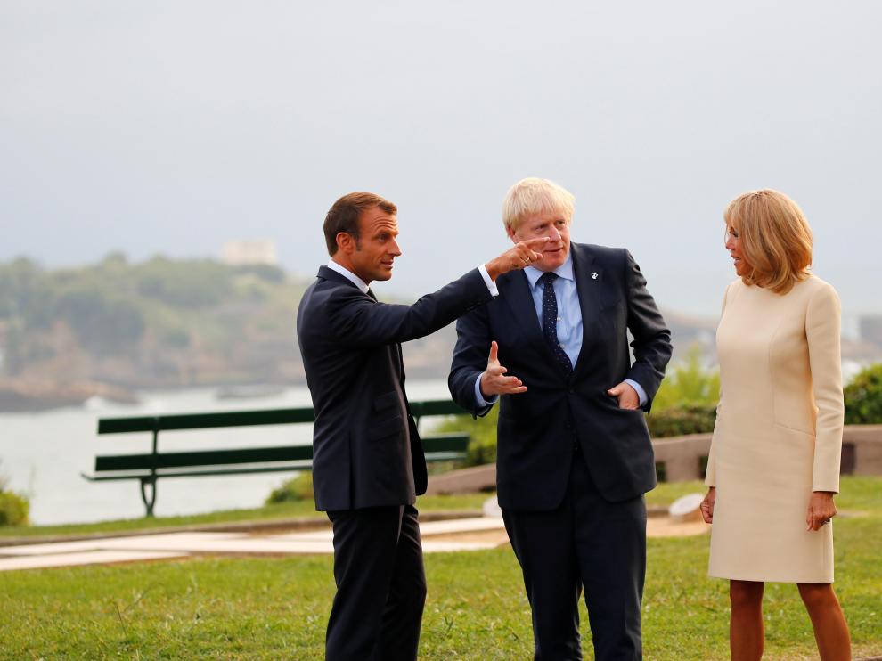 El presidente francés y su mujer conversan con el primer ministro británico.