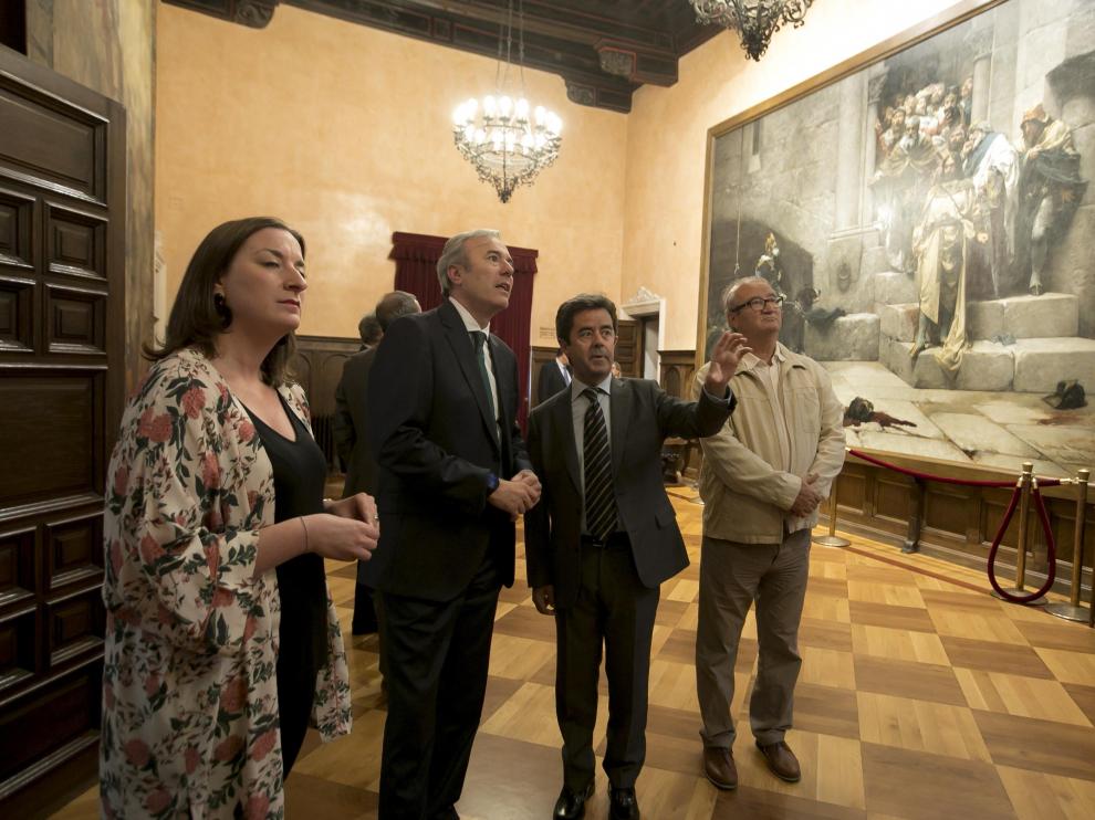 Luis Felipe junto a Jorge Azcón y los concejales de Huesca María Rodrigo y José María Romance en el salón del Justicia, con el célebre cuadro de la Campana de Huesca.