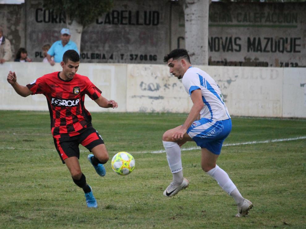 Un jugador del Sariñena pugna el balón contra un rival del Tamarite.
