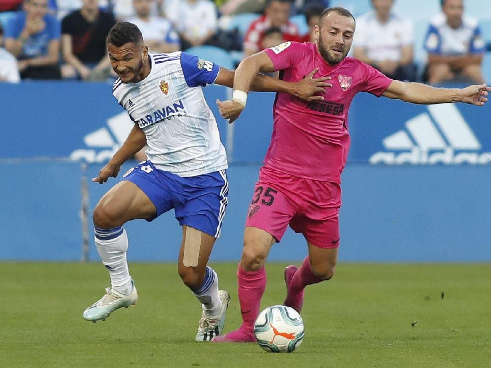 Luis Suárez pugna con el malacitano Keidi Bare en el partido Real Zaragoza-Málaga de este jueves.