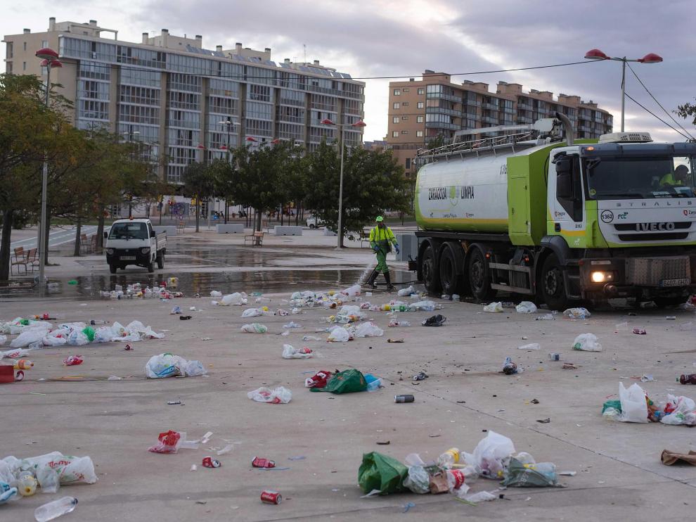 Operarios de FCC limpian a primera hora la enorme cantidad de basura que se acumula en el botellón de Valdespartera