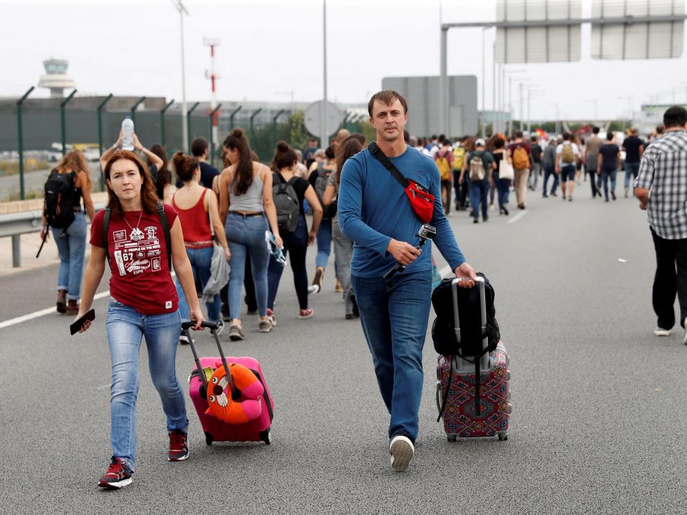 Dos pasajeros llegan caminando al aeropuerto del Prat.