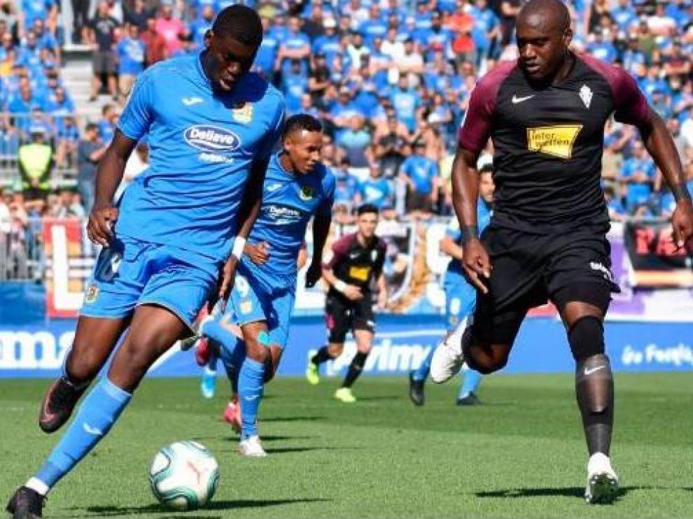 Nteka, mediapunta del Fuenlabrada, conduce el balón ante el central del Sporting de Gijón Babin, en el último partido de los madrileños en su estadio, donde ganaron 2-0.