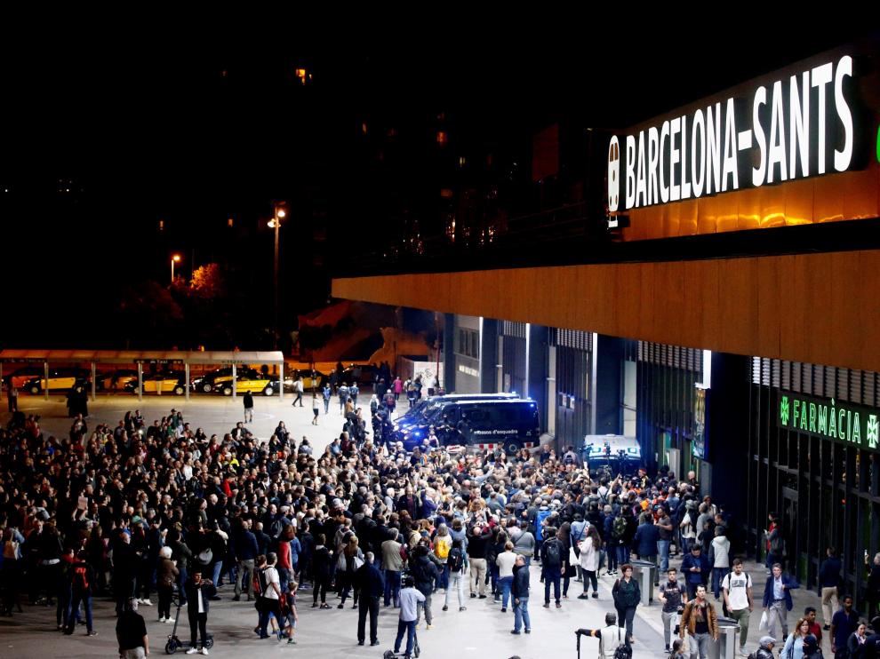 Miembros de los CDR, ante uno de los accesos a Sants, custodiado por los Mossos.