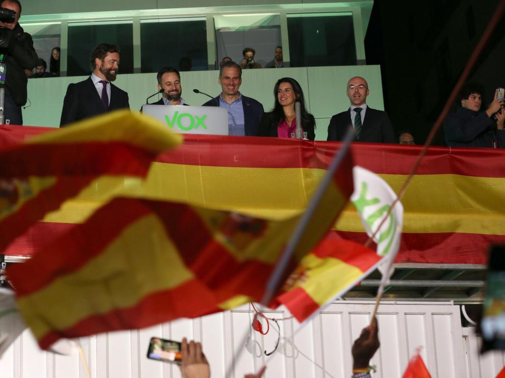 El equipo de Vox saluda a sus simpatizantes en el exterior de la sede de Madrid durante el seguimiento de la noche electoral.