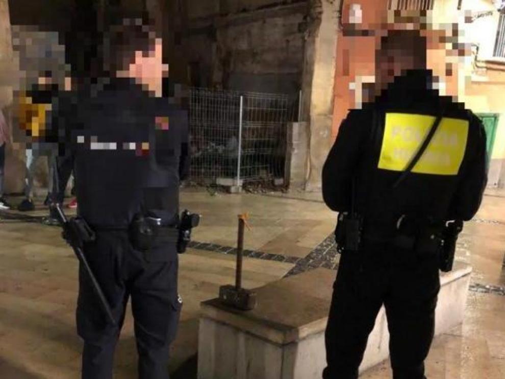 Dos policías, con el martillo que utilizó el transeúnte.