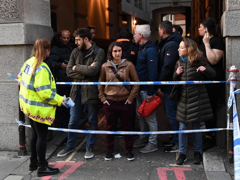 Una policía junto a varias personas en el puente de Londres.