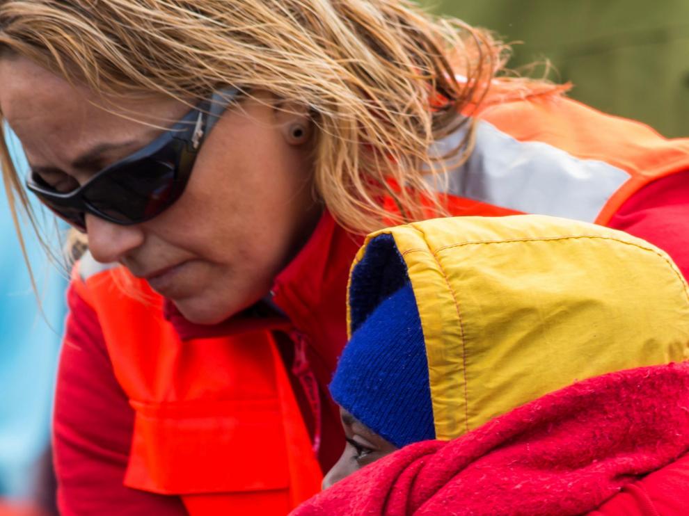 Varios bañistas atienden a un grupo de inmigrantes llegados en patera a Canarias.