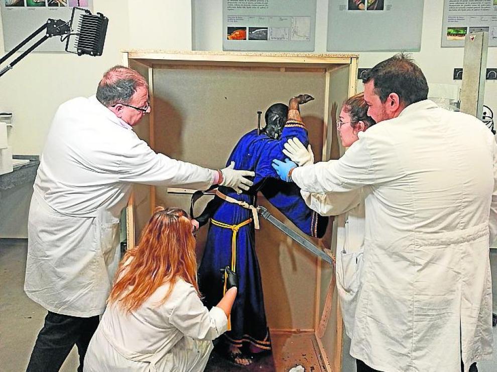 Personal de la facultad de Sevilla desembala el Cristo.