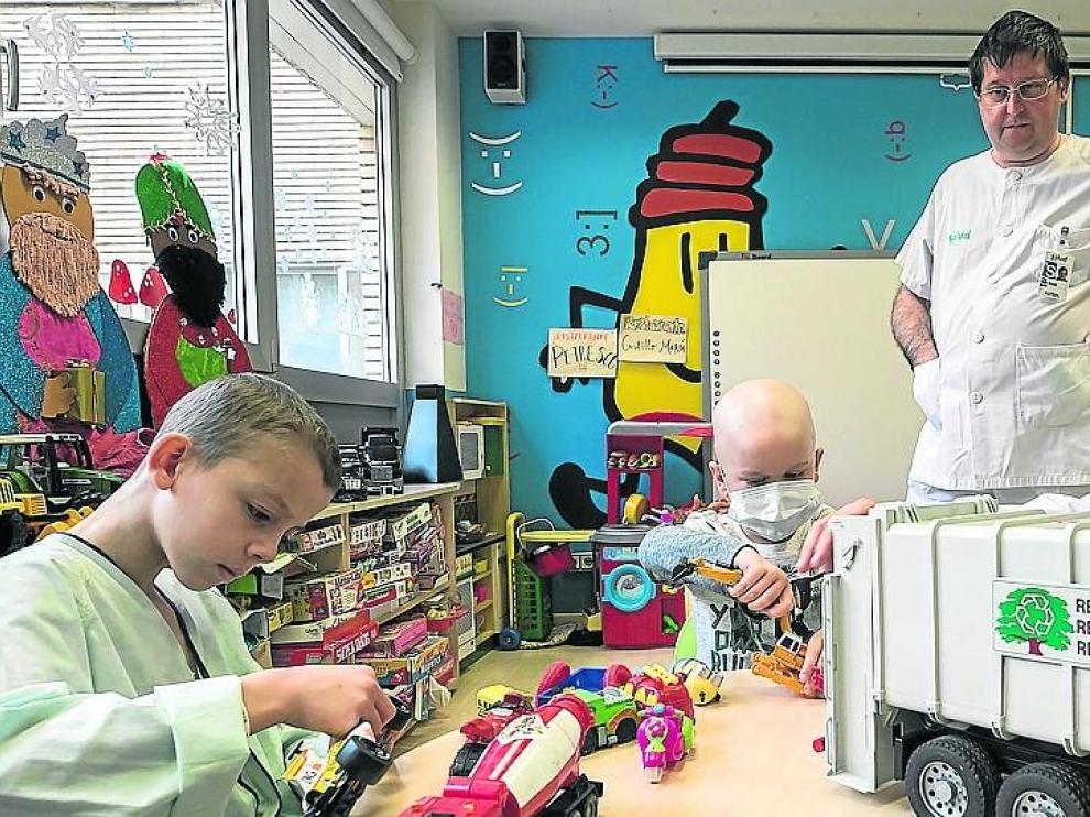 Adam y Mario juegan con una variada colección de coches en el aula educativa